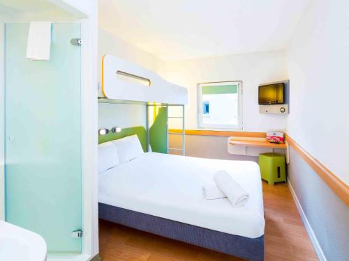 a bedroom with a white bed and a desk at ibis budget Glasgow in Glasgow