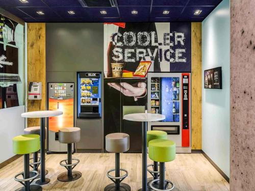 a restaurant with a vending machine and stools at Ibis budget Hannover Hbf in Hannover