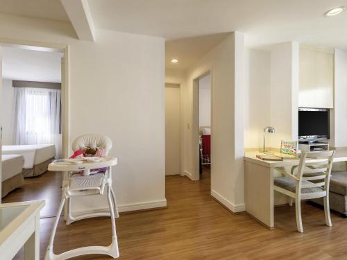 a living room with a bed and a table and chairs at Mercure Sao Paulo Moema in Sao Paulo