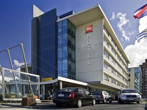 a building with cars parked in front of it at ibis Montevideo Rambla in Montevideo