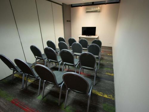 a room with chairs and a table and a screen at ibis Montevideo Rambla in Montevideo