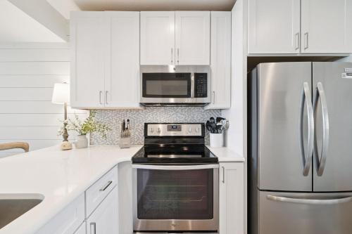 kuchnia z białymi szafkami i lodówką ze stali nierdzewnej w obiekcie HP 34W On the Shore by 30A Escapes w mieście Rosemary Beach