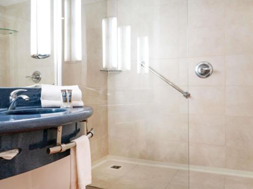 a bathroom with a sink and a shower at Novotel Monterrey Valle in Monterrey