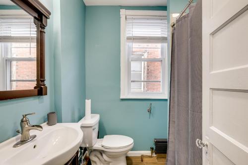 Un baño con inodoro, lavabo y ventana. en Private Backyard Jawn! Multi-Level Philly Rowhouse, en Filadelfia