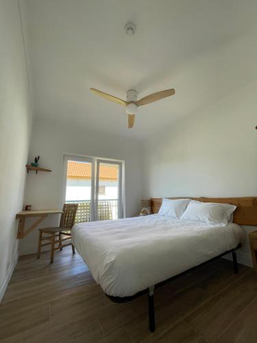 a bedroom with a bed with a ceiling fan at Wild Souls Guesthouse in Ericeira