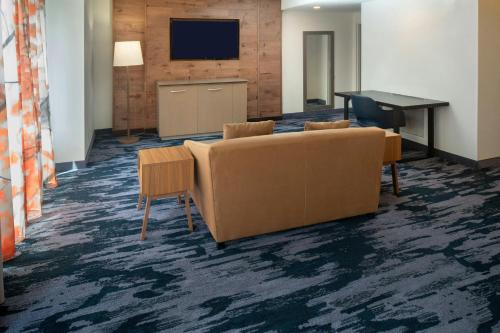 a lobby with a couch and a table and a television at Fairfield Inn & Suites by Marriott Savannah Midtown in Savannah