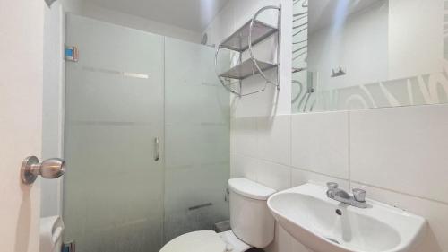 Un baño con inodoro, lavabo y ducha. en Dúplex con Terraza en Condominio Los Parques del Callao, en San Antonio
