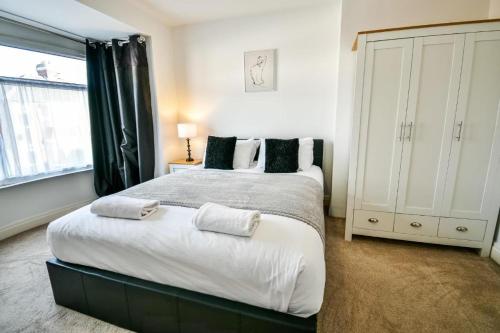 a bedroom with a large bed and a window at Buckingham Terrace - 4 Bedrooms - Sleeps 7 in Redcar