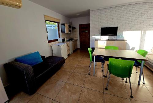 a living room with a table and green chairs at Monti Domki całoroczne in Mierzyn