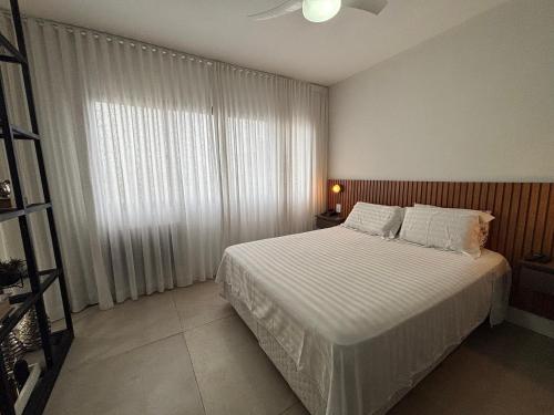 a bedroom with a bed and a large window at ENB Flat Super Moderno com AC no Centro de SBC in São Bernardo do Campo