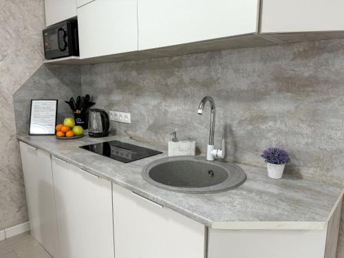 eine Küchentheke mit Spüle und Obst darauf in der Unterkunft 1-комнатная квартира в центре на 1 Мая 81 in Qostanai