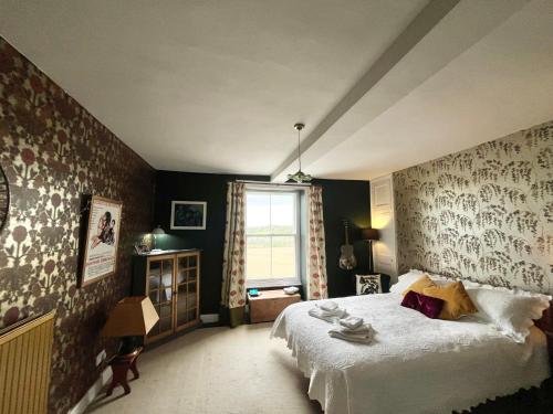 The Master Suite, Cotswolds Coaching Inn في Naunton: غرفة نوم بسرير كبير ونافذة