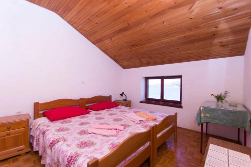 a bedroom with a bed and a wooden ceiling at Sobe Andreis in Vela Luka