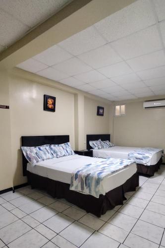 two beds are sitting in a room at Hotel Paris in Machala