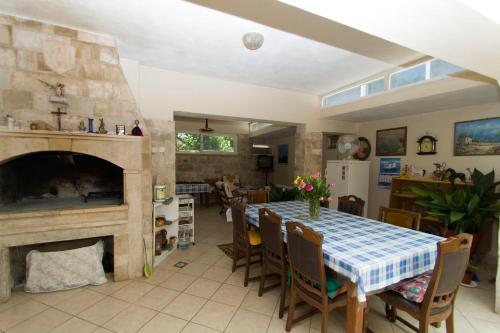 a dining room with a table and a fireplace at Sobe Andreis in Vela Luka