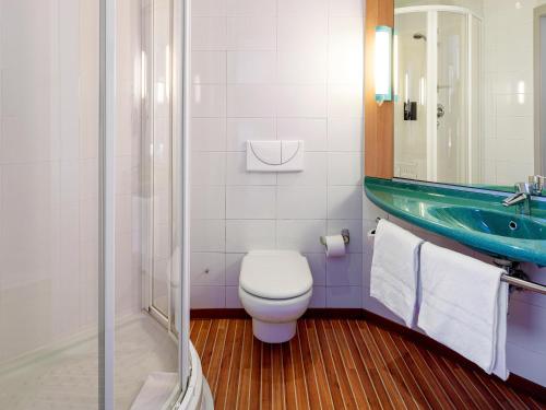 a bathroom with a toilet and a sink at Ibis Madrid Getafe in Getafe