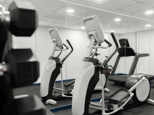 a gym with two exercise bikes in a room at Mövenpick Hotel Budapest Centre in Budapest