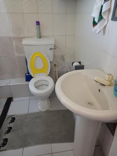 a bathroom with a white toilet and a sink at Pebs one bedroom apartment in Mombasa