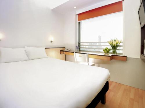 a bedroom with a large white bed and a window at ibis Hong Kong North Point in Hong Kong