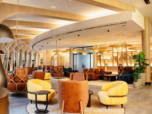 a lobby with yellow chairs and a waiting room at Ibis World Trade Centre in Dubai