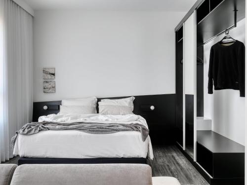 a black and white bedroom with a bed and a closet at Mercure Belo Horizonte Lourdes in Belo Horizonte