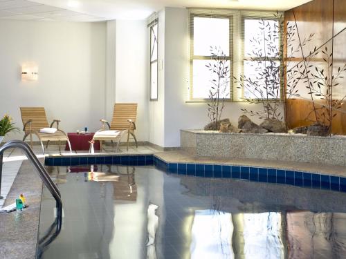 a swimming pool in a hotel room with a swimming pool at Mercure Belo Horizonte Lourdes in Belo Horizonte