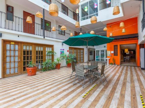a patio with a table and chairs and an umbrella at Oaxaca Guest Hotel in Oaxaca City