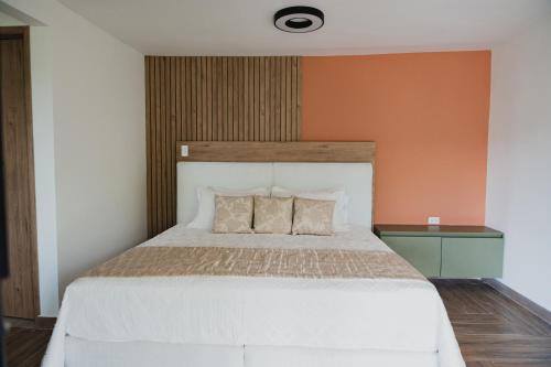 a bedroom with a large white bed with an orange wall at Antara Resort in Alcalá