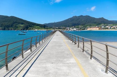 a bridge over a body of water with boats at As Cañotas in Cariño