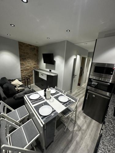 a living room with a table with chairs and a kitchen at As Cañotas in Cariño