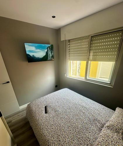 a bedroom with a bed and a window with blinds at As Cañotas in Cariño