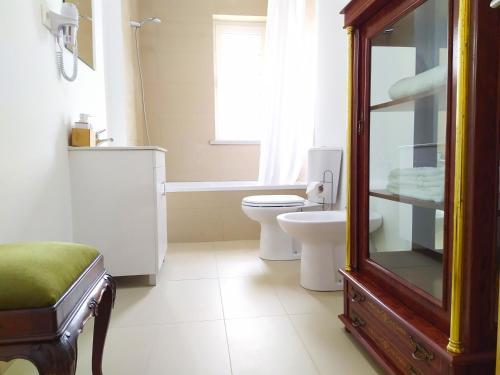 un bagno con un water, un lavandino e uno specchio di Gardunha Apartments Avenida V a Fundão