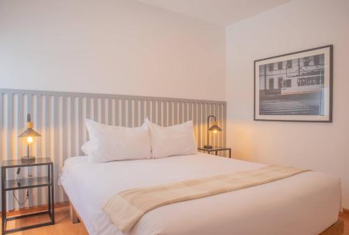 a bedroom with a large white bed with two lamps at Sleek 2BR in Miraflores in Lima