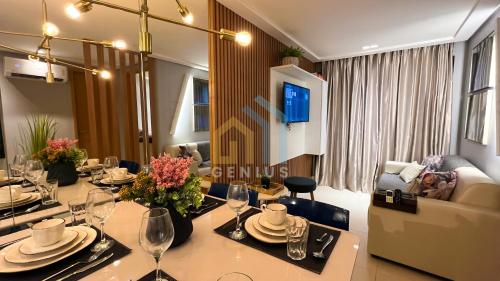 a dining room with a table with plates and wine glasses at Eco Summer Tambaú WB Genius Flats in João Pessoa