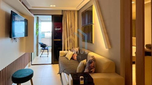 a woman sitting on a couch in a living room at Eco Summer Tambaú WB Genius Flats in João Pessoa