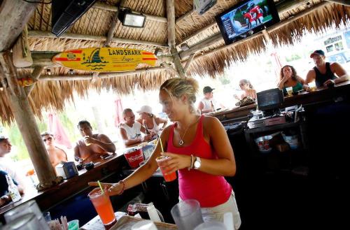 a woman standing at a bar with a drink at Entire Siesta Key Beach House - 6 BR, Pool & Ocean Access in Siesta Key