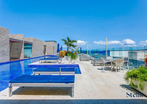 ein Pool mit Tischen und Stühlen auf einem Gebäude in der Unterkunft Condos with Private Jacuzzi and shared Ocean View Roof pool in Playa del Carmen