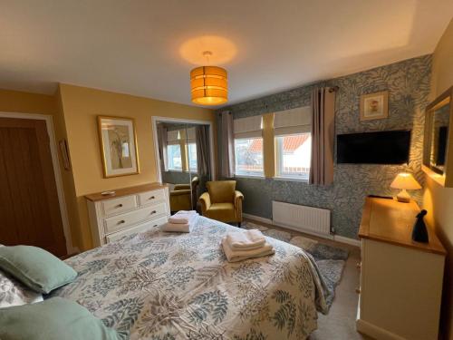 a bedroom with a bed with towels on it at Lighthouse Cottage Cullen in Cullen