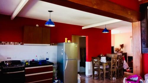 a kitchen with red walls and a stainless steel refrigerator at Casa Tanti in Tanti