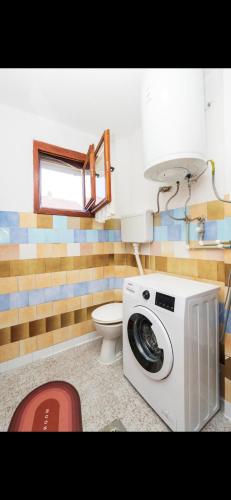 a washing machine in a bathroom with a toilet at Guest House Bakovic in Plav