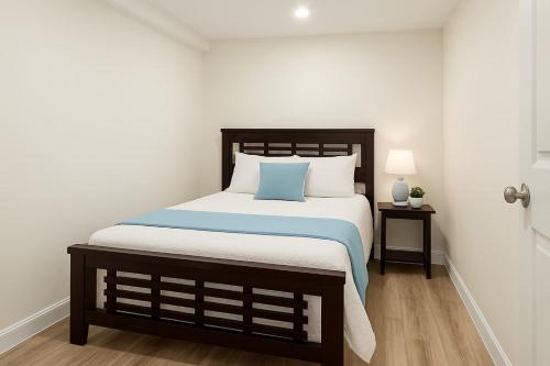 Oak BayにあるMelrose Place Poolside Hideaway Basement Suite Sleeps 6 plusの木製のヘッドボードが付いた大きなベッドのある寝室