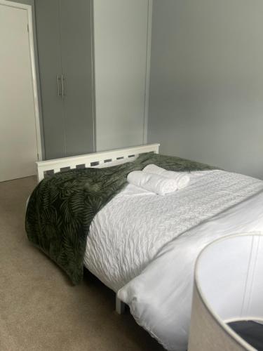a bedroom with a large bed with white sheets at Northolt Place in Northolt