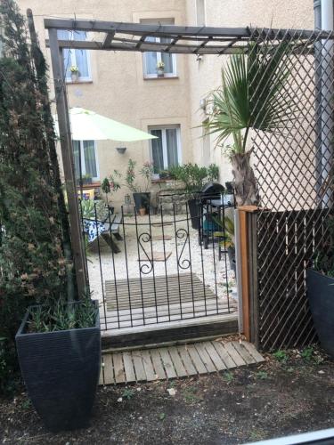 a fence with a gate with a potted plant at Chambre la paix in Payrac