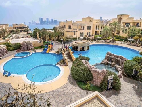 a large swimming pool in a resort at Novotel Bahrain Al Dana Resort in Manama