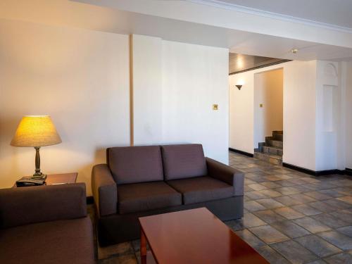 a living room with a couch and a table at Novotel Bahrain Al Dana Resort in Manama