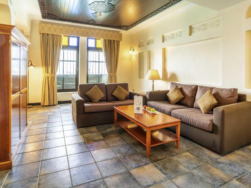 a living room with two couches and a coffee table at Novotel Bahrain Al Dana Resort in Manama
