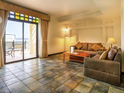 a living room with a couch and a table at Novotel Bahrain Al Dana Resort in Manama