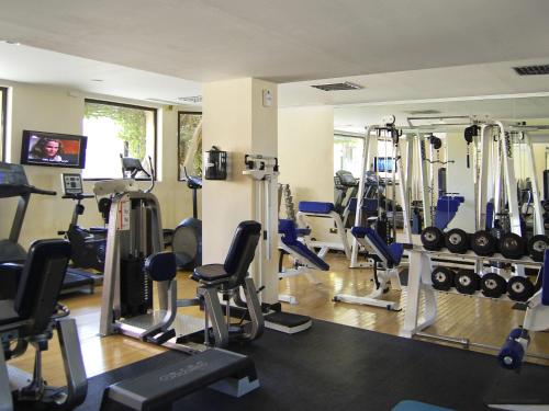 a gym with a lot of treadmills and weights at Novotel Bahrain Al Dana Resort in Manama