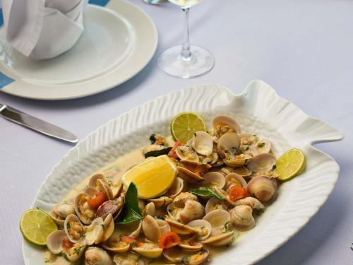 a plate of food with mushrooms and lemons on a table at Novotel Bahrain Al Dana Resort in Manama