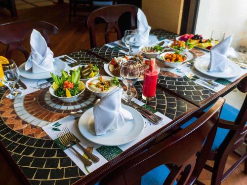 a table with plates and bowls of food on it at Novotel Bahrain Al Dana Resort in Manama